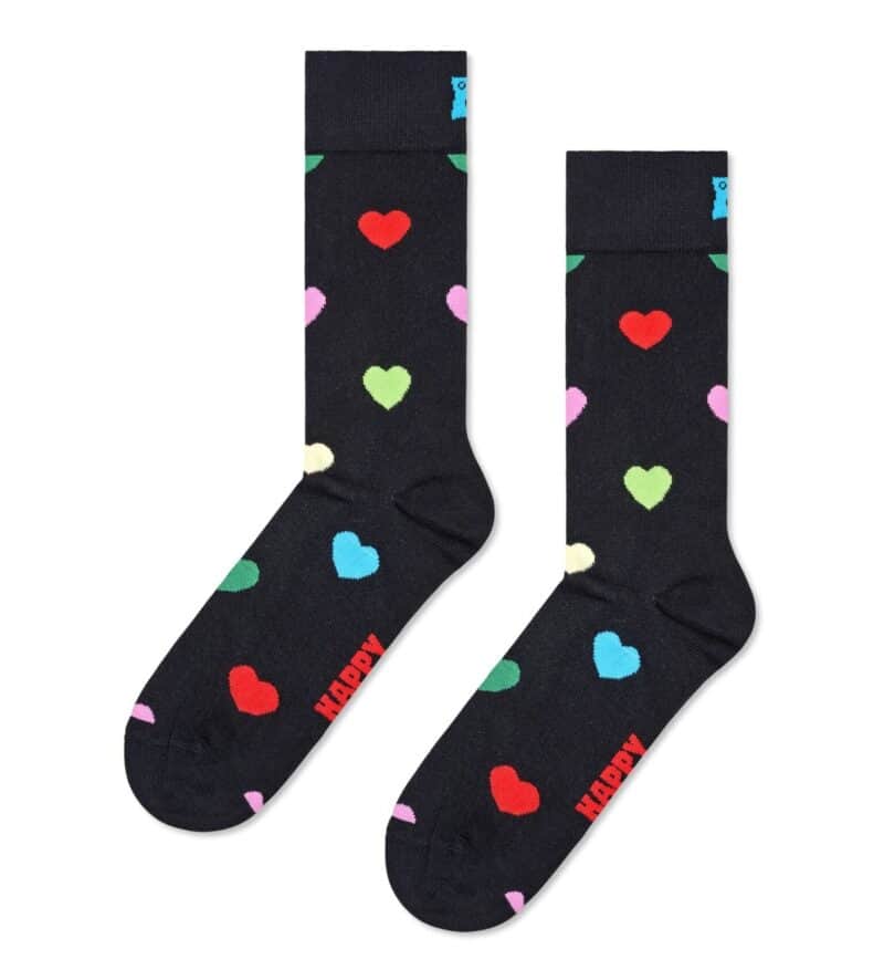 Colorful heart patterned socks with red, pink, green, blue, and white hearts on a black background.