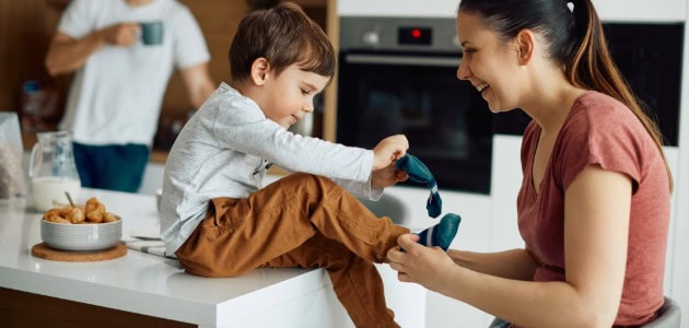 Child putting on colorful socks, cozy home setting, family activity.